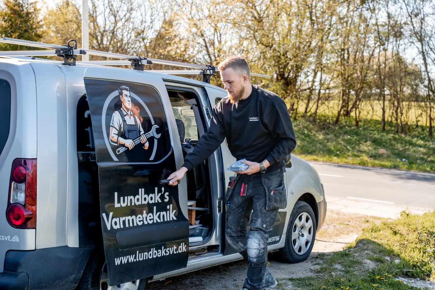 Erik ved firmabilen med Lundbak's Varmeteknik-logo