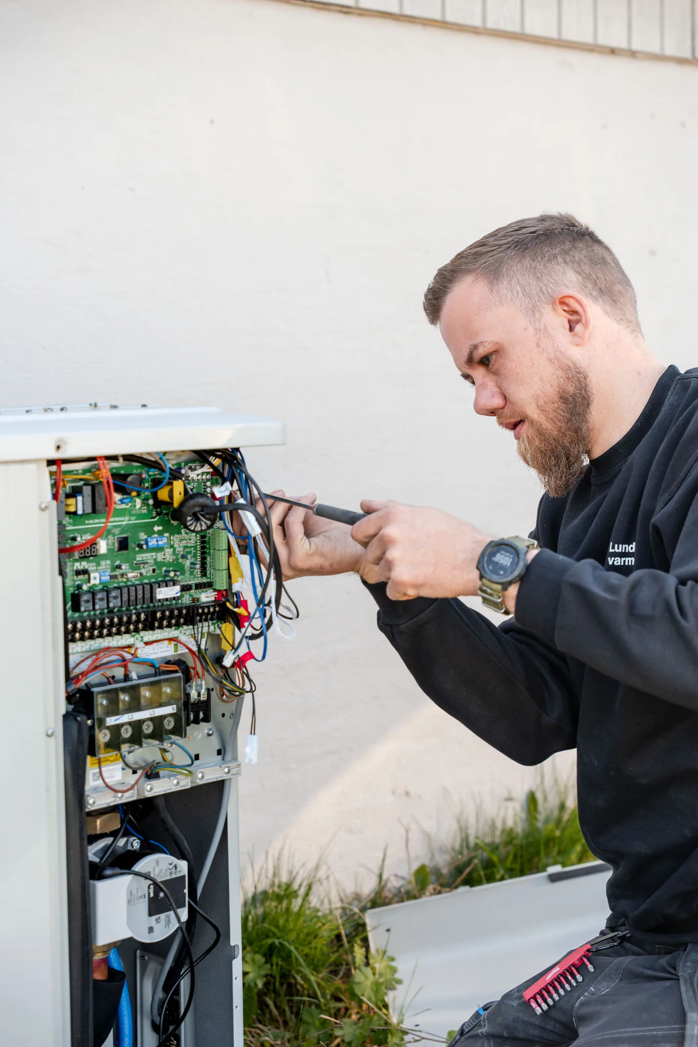 Erik servicerer varmepumpe — Lundbak's Varmeteknik